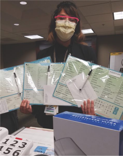 woman holding printouts in multiple languages