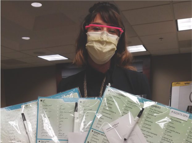 woman holding printouts in multiple languages