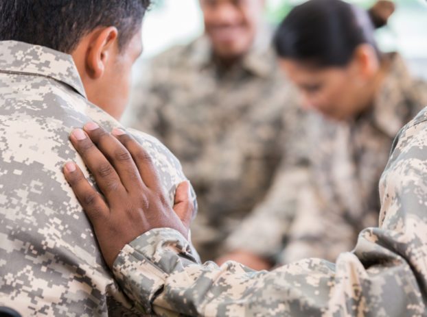 group of soldiers comforting each other