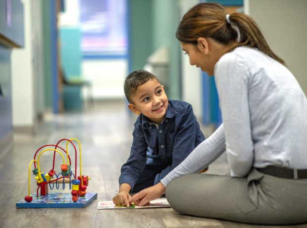 woman playing with kid in doctors office