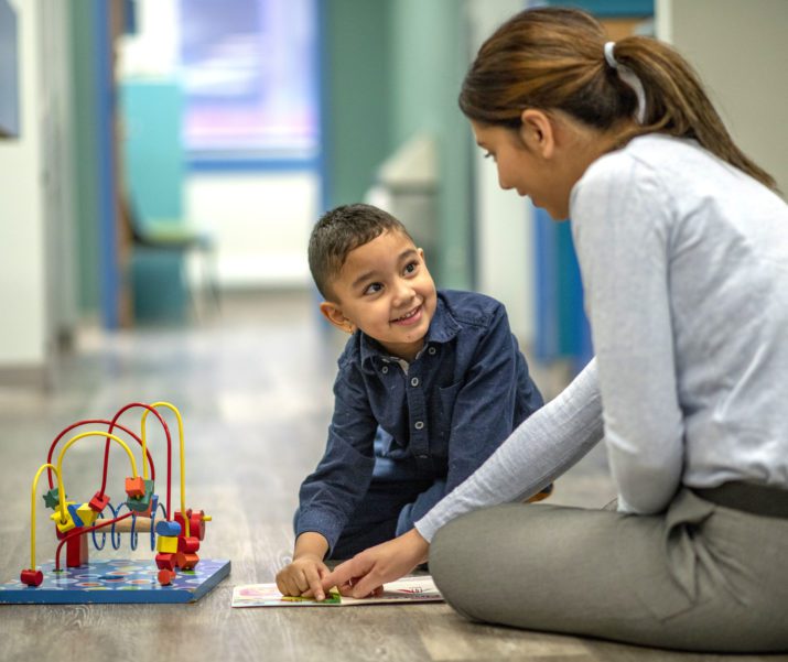 woman playing with kid in doctors office