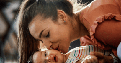 Brunette woman kissing brunette baby