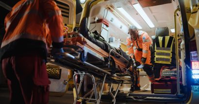 Team of EMS Paramedics React Quick to Bring Injured Patient to Healthcare Hospital and Get Him Out of Ambulance on a Stretcher. Emergency Care Assistants Help Young Man to Stay Alive After Accident.