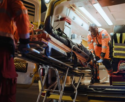 Team of EMS Paramedics React Quick to Bring Injured Patient to Healthcare Hospital and Get Him Out of Ambulance on a Stretcher. Emergency Care Assistants Help Young Man to Stay Alive After Accident.
